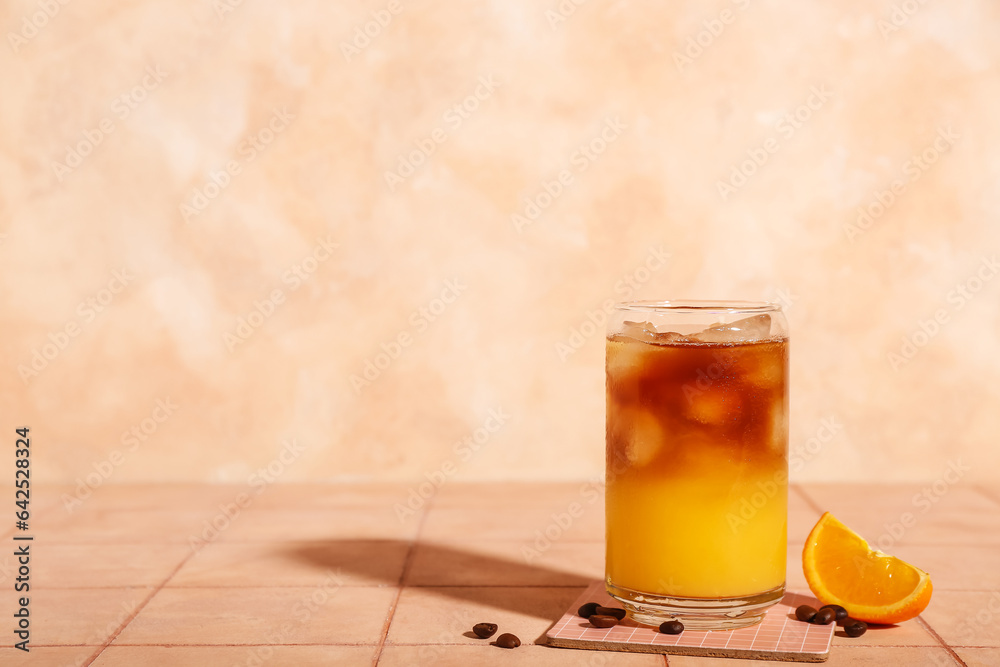 Glass of tasty orange espresso on table