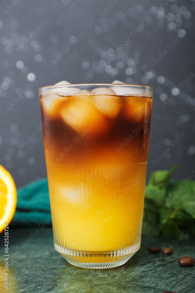 Glass of tasty orange espresso on table