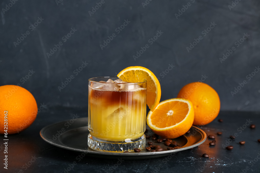 Glass of cold orange espresso on black background