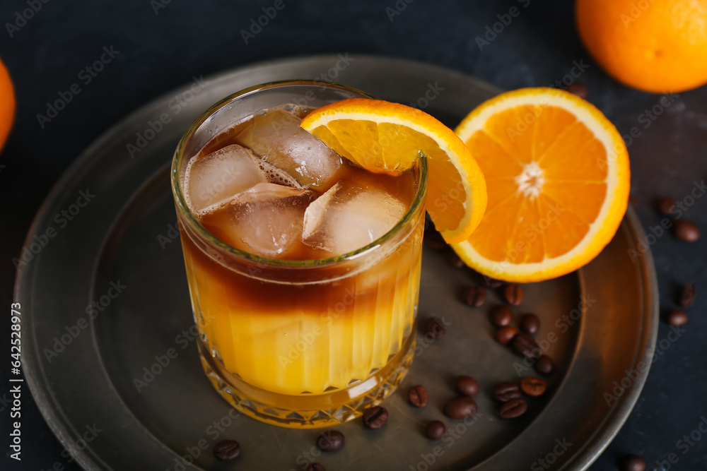 Glass of cold orange espresso on black background