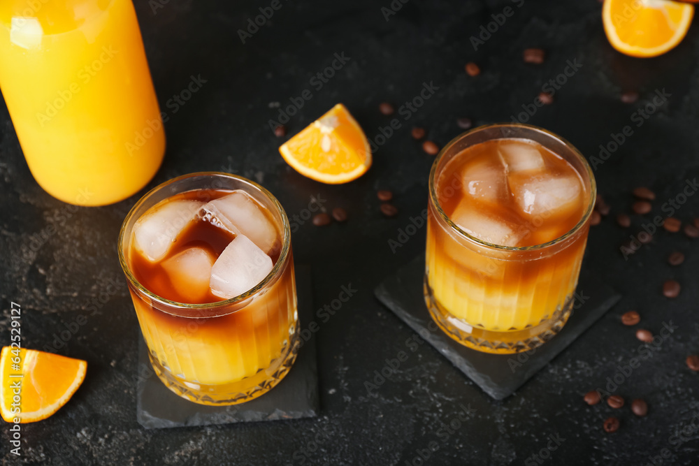 Glasses of cold orange espresso on black background