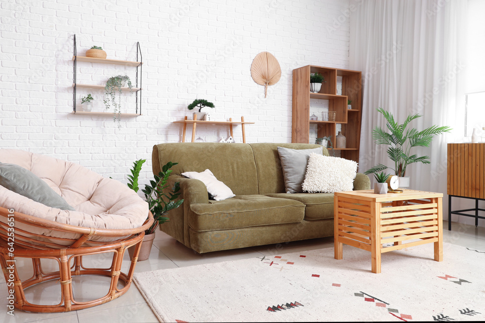 Interior of stylish living room with cozy armchair and green sofa