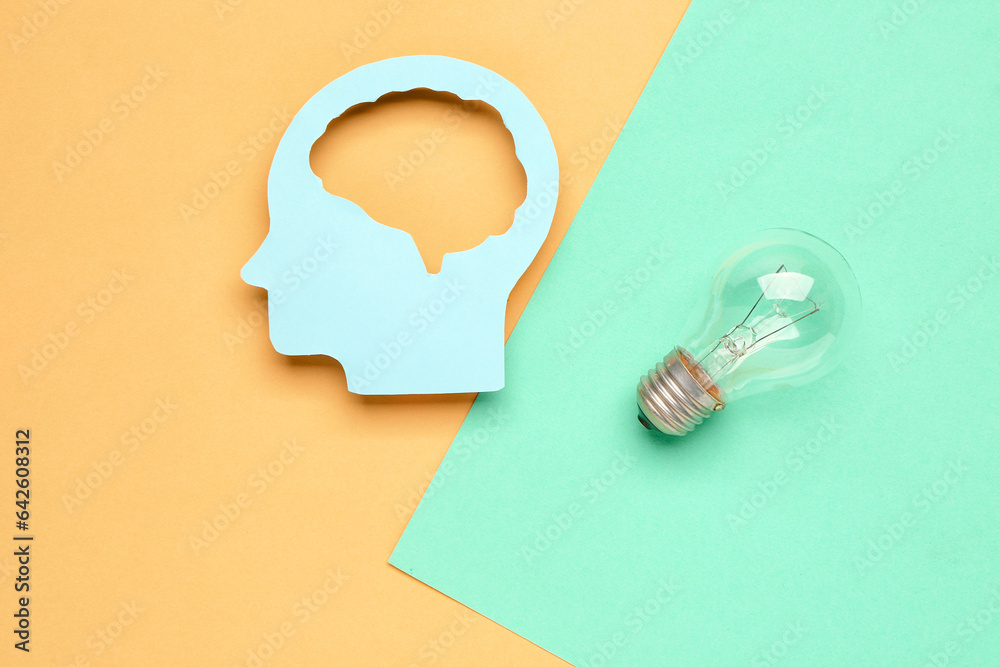 Paper human head with light bulb on color background. Logic concept