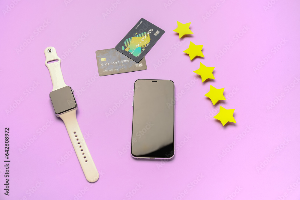 Five stars with mobile phone, smartwatch and credit cards on lilac background. Customer experience c