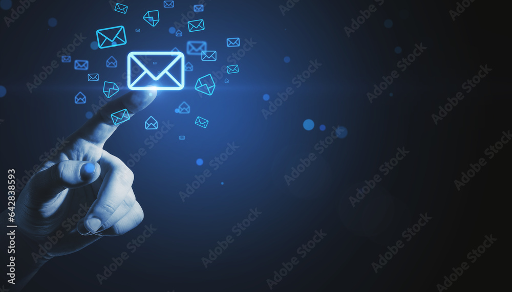 Close up of businessman hand pointing at glowing email letter icons on dark blue background with moc