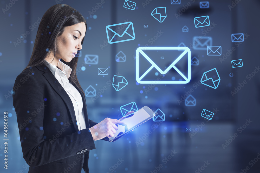 Attractive europeaqn businesswoman using mobile phone with glowing email letter icons on blurry offi