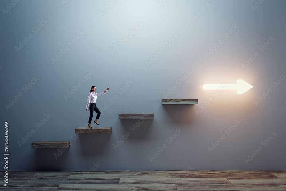 Side view of young business woman climbing illuminated arrow stairs to success on concrete wall back