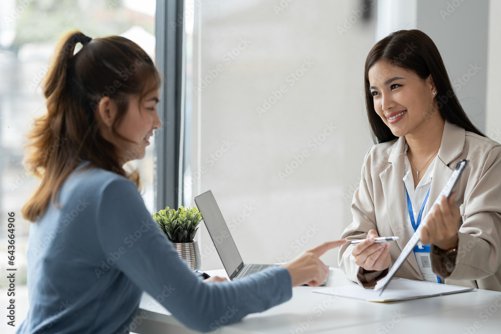 Businesswoman, office worker working using laptop and mobile phone in real estate accounting analysi