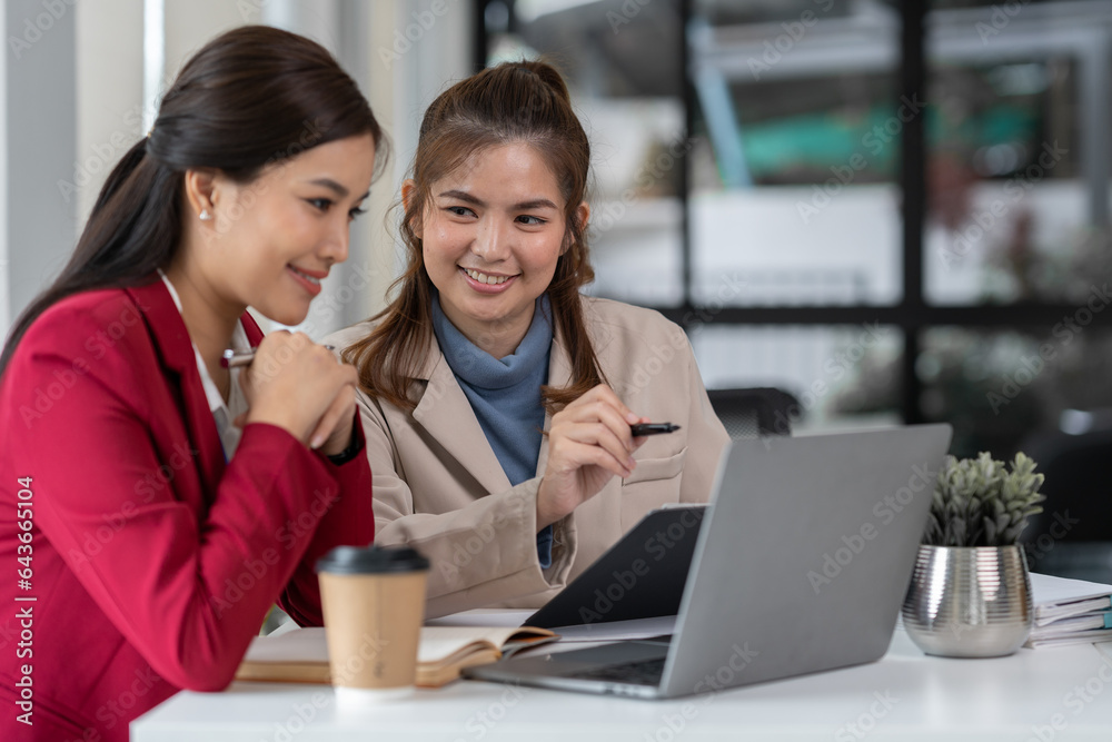 team work process Two asian businesswoman working with laptop computer and discussing documents proj