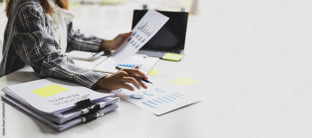 Business woman working on paperwork in the office, analysis of financial charts in business reports.