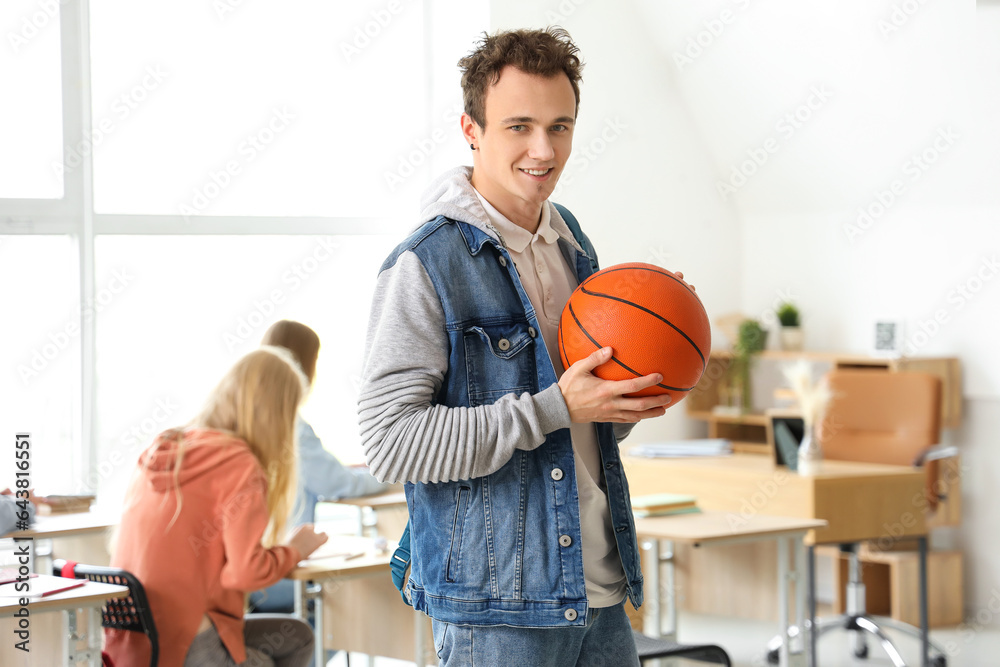 Male student with ball in classroom