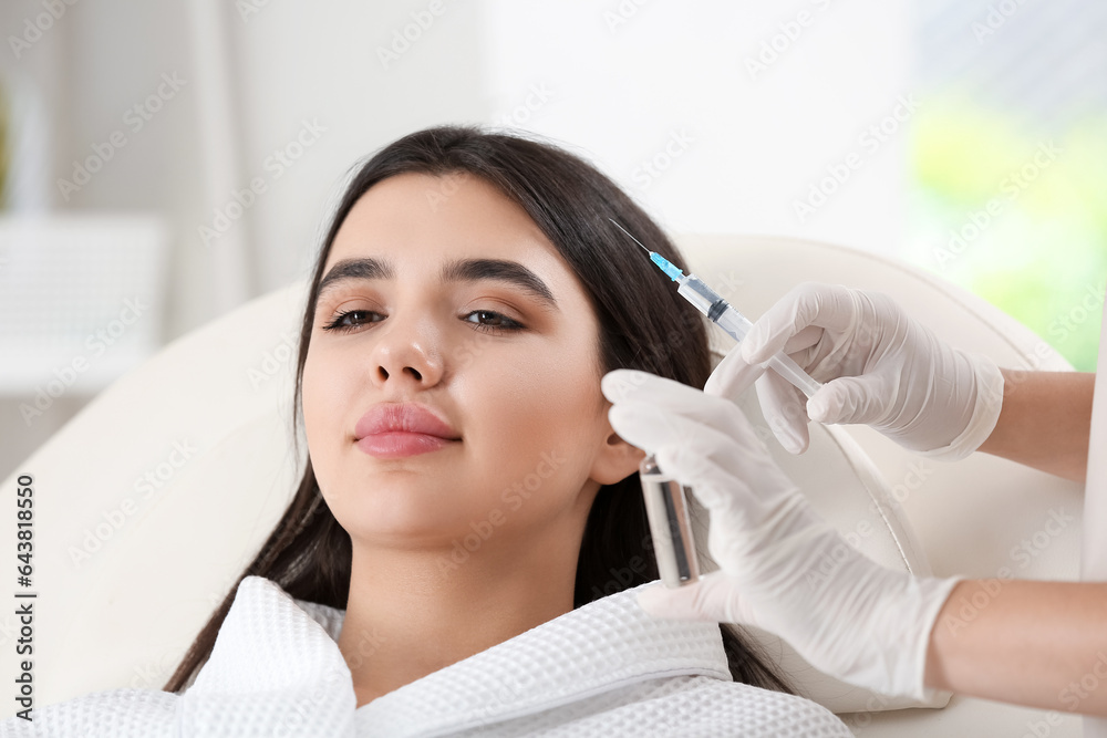 Young woman receiving injection in beauty salon, closeup