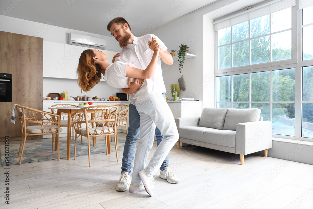 Happy couple in love dancing in kitchen