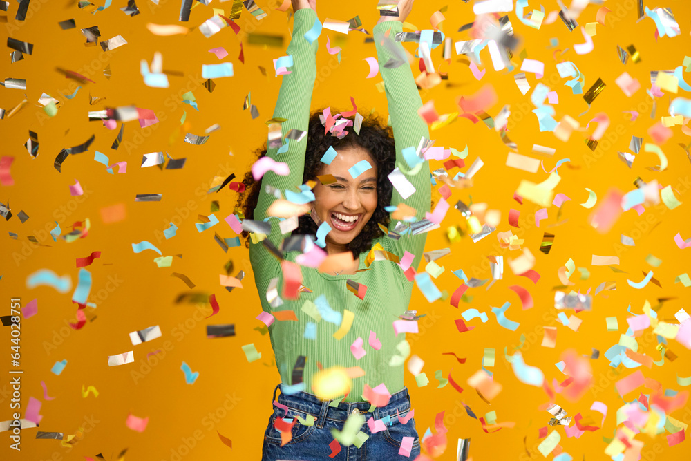 Studio Shot Of Excited Woman Celebrating Big Win Showered In Tinsel Confetti On Yellow Background