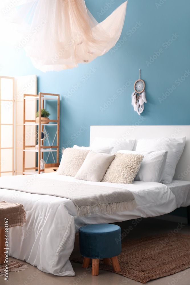 Interior of bedroom with dream catcher and bed