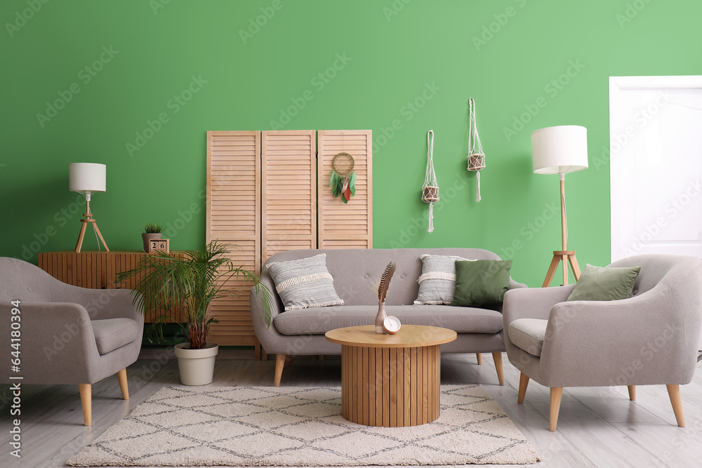 Interior of living room with sofa and dream catcher on folding screen