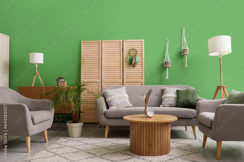 Interior of living room with sofa and dream catcher on folding screen