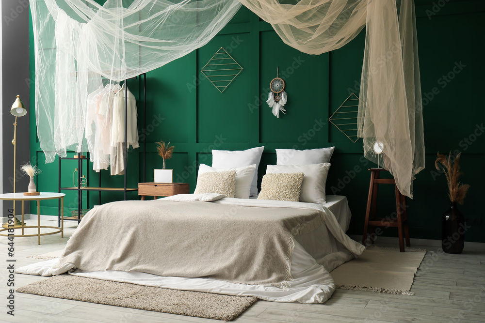 Interior of stylish bedroom with curtain and dream catcher on green wall