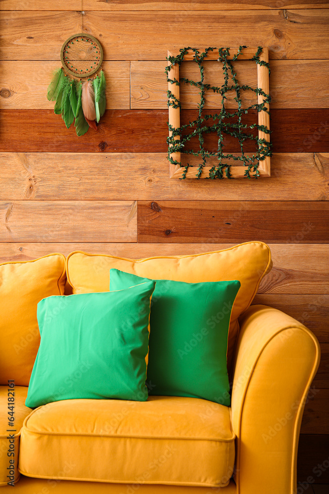 Interior of living room with frame and dream catcher on wooden wall