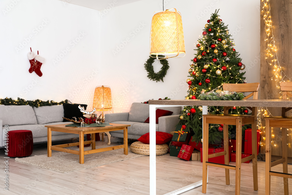 Interior of living room with Christmas tree, sofas and coffee table