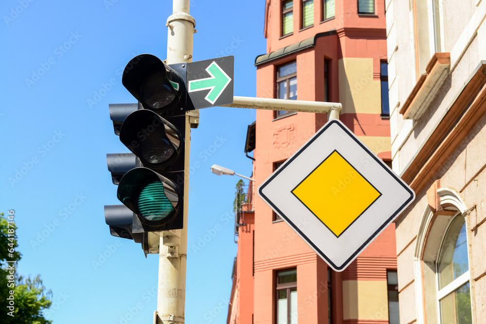 View of green traffic light with road signs in city, closeup