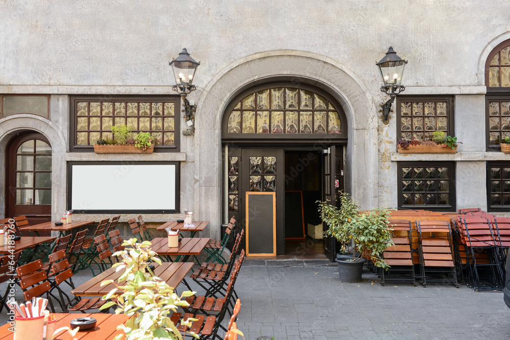 Facade of restaurant with tables and chairs on city street