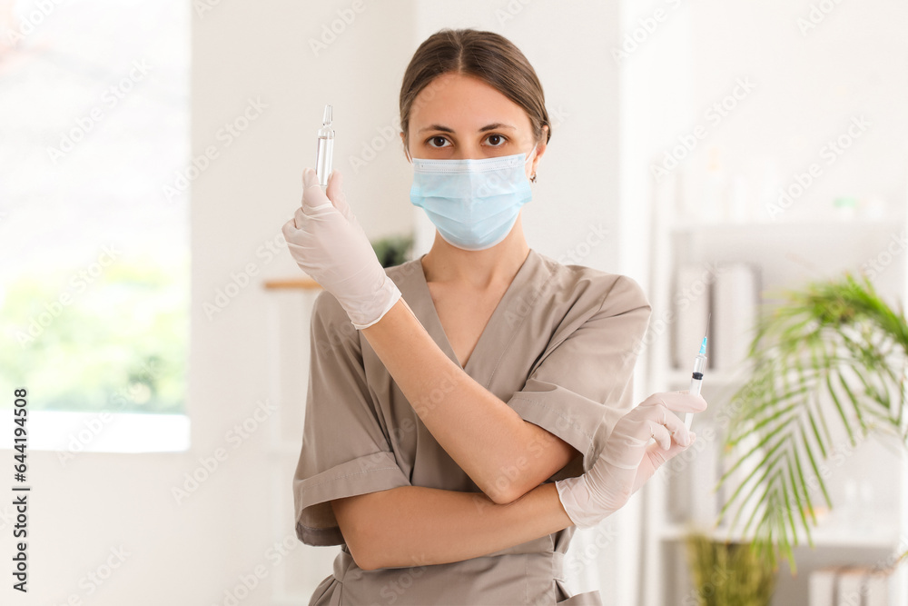 Female cosmetologist with syringe and ampule in beauty salon