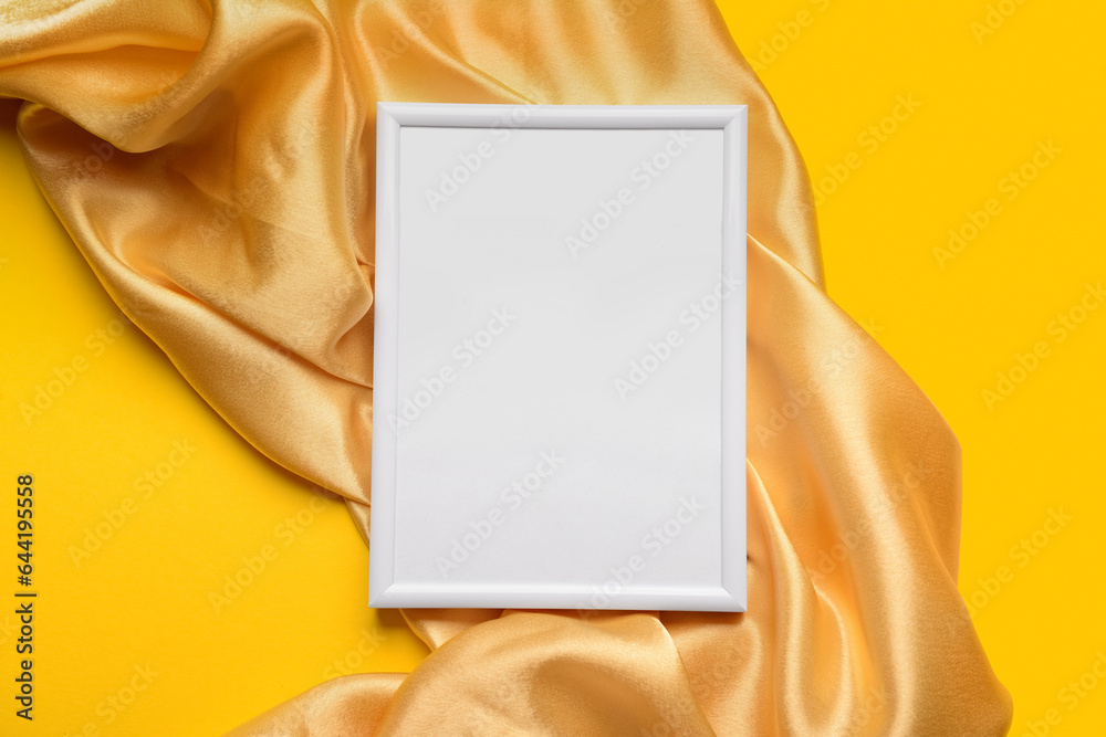 Blank picture frame with fabric on yellow background