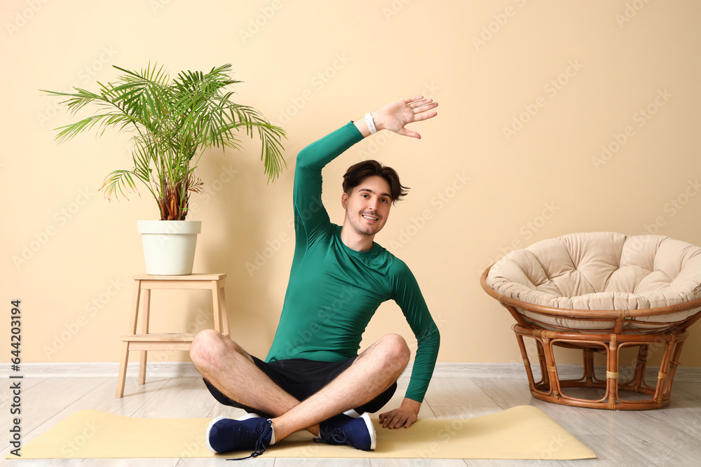 Sporty young man stretching at home