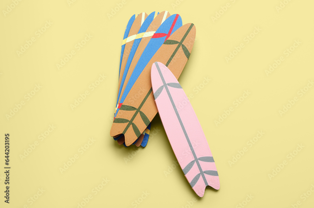 Different mini surfboards on yellow background