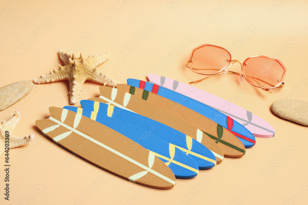 Different mini surfboards, starfishes and sunglasses on yellow background