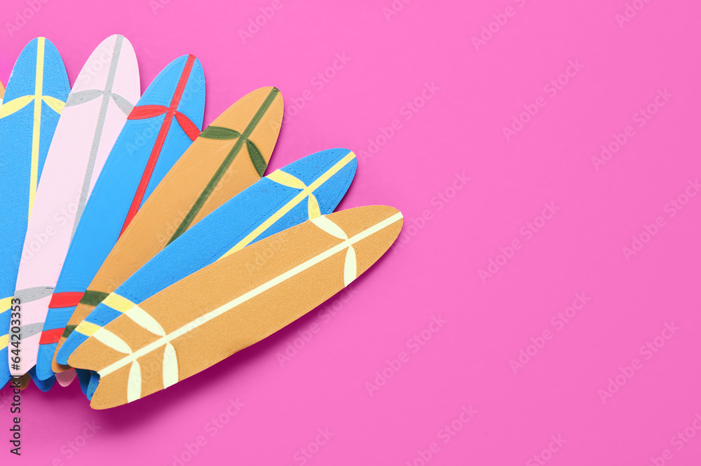 Different mini surfboards on pink background