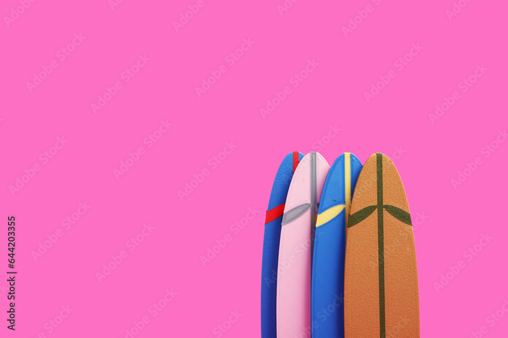 Different mini surfboards on pink background