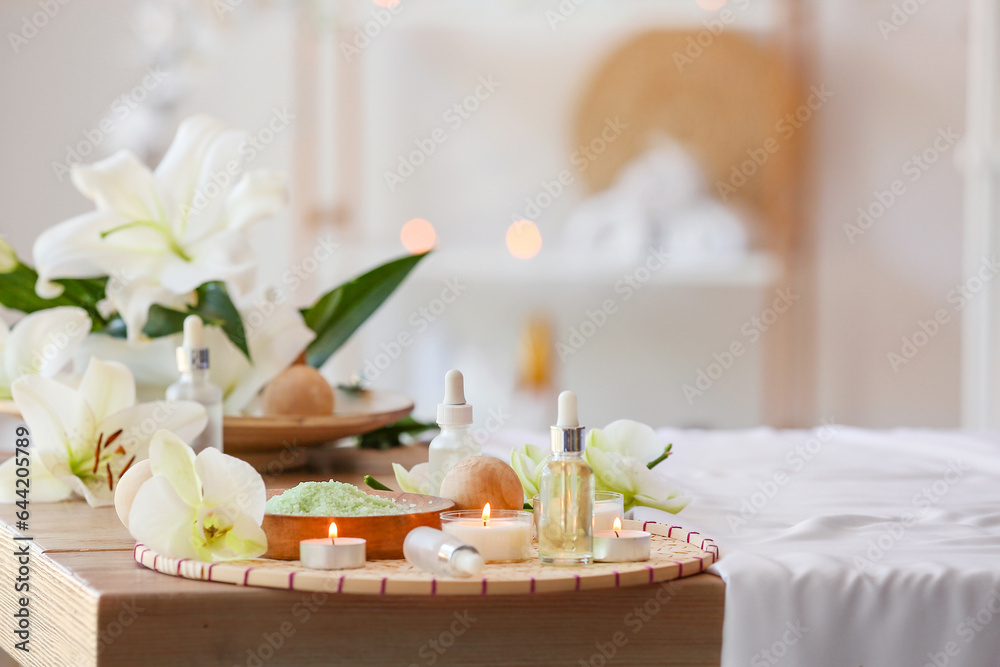 Spa composition with flowers and burning candles in salon, closeup