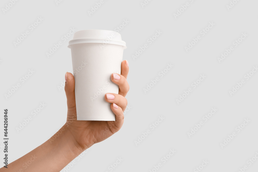 Woman with takeaway cup of hot coffee on white background