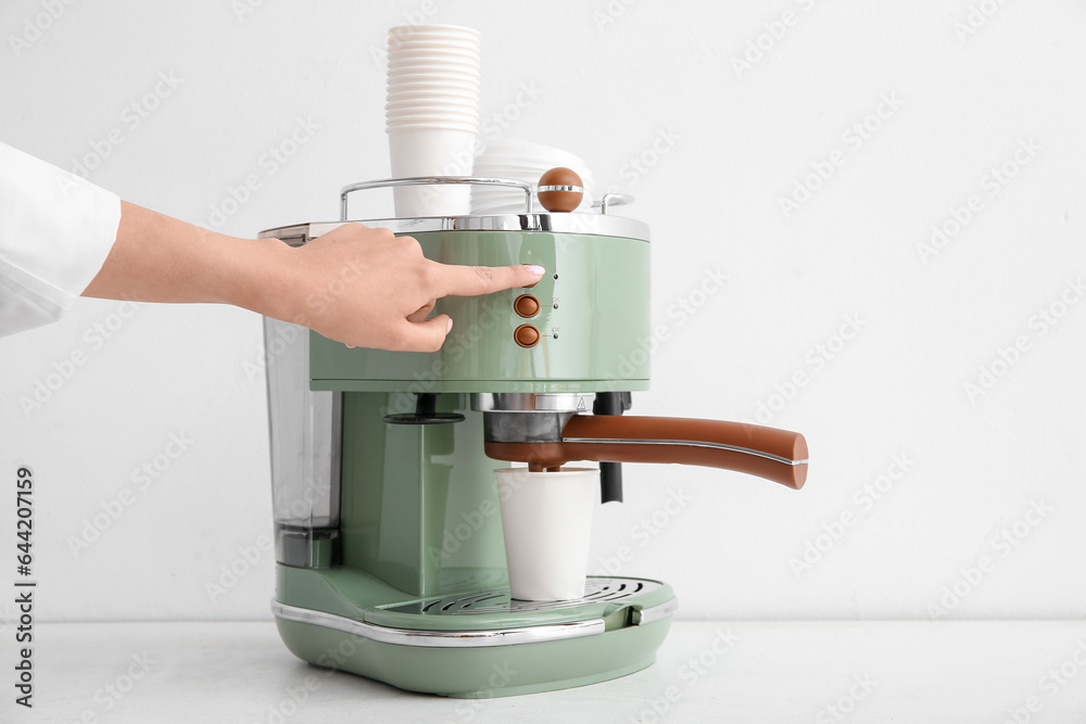 Woman preparing hot coffee on white background