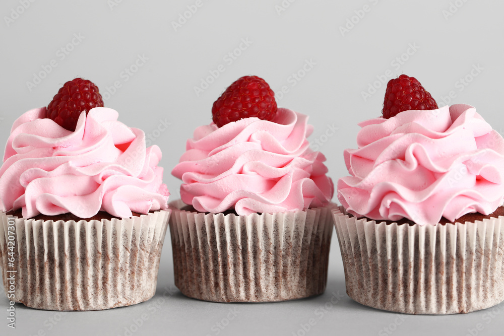 Tasty raspberry cupcakes on grey background