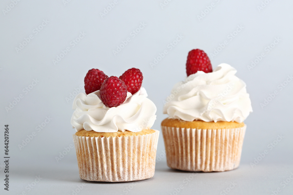 Tasty raspberry cupcakes on grey background