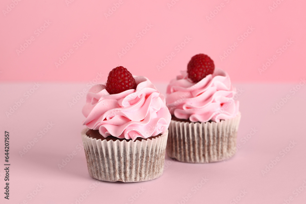 Tasty raspberry cupcakes on pink background