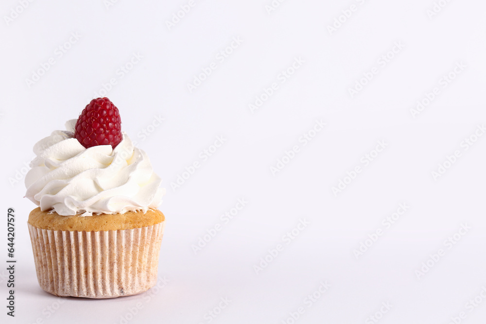 Tasty raspberry cupcake on grey background