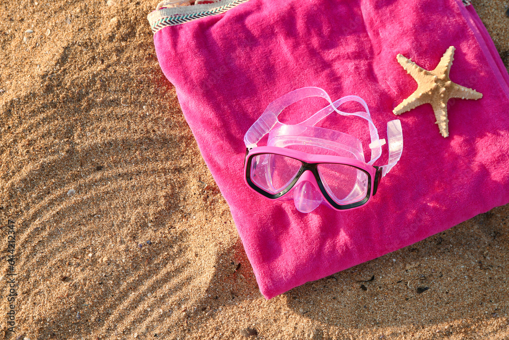 New swimming mask, starfish and towel on sand