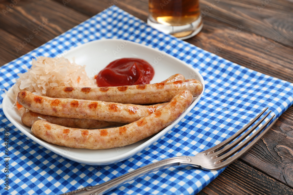 Plate with tasty Bavarian sausages, sauce and sauerkraut on wooden background. Oktoberfest celebrati