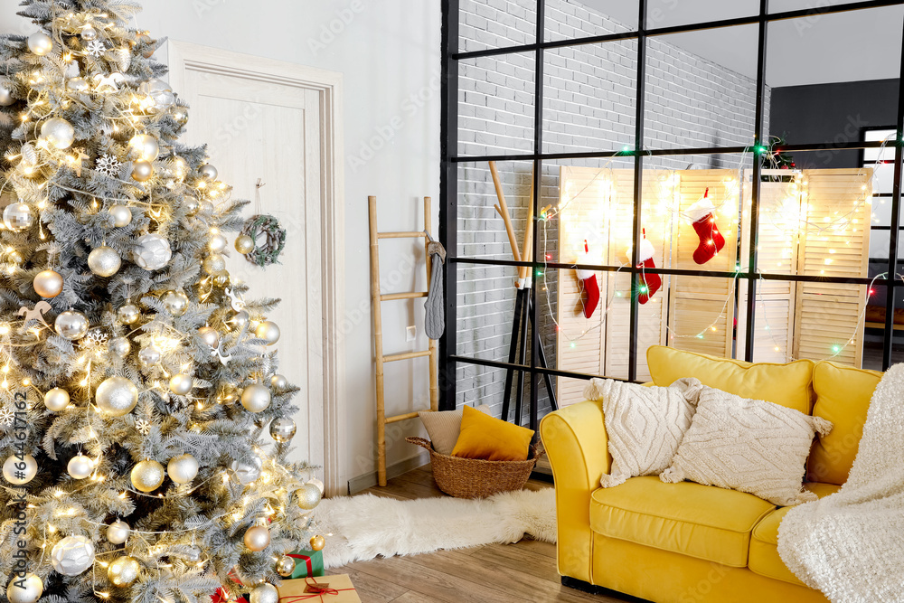 Interior of living room with Christmas tree, yellow sofa and folding screen