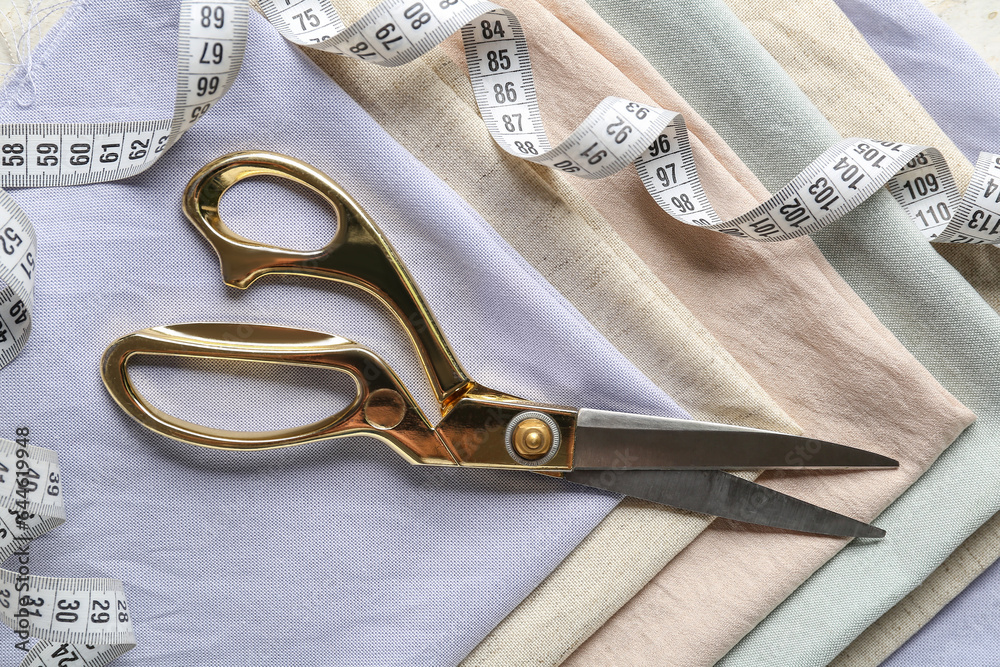 Set of fabrics, scissors and measuring tape, closeup