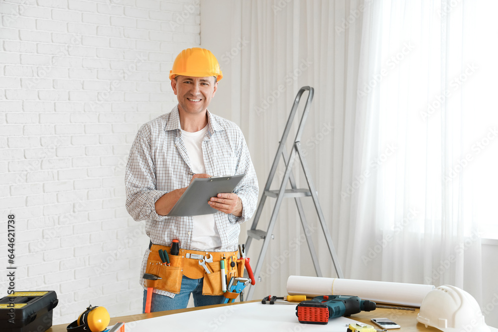 Mature builder with clipboard working in room