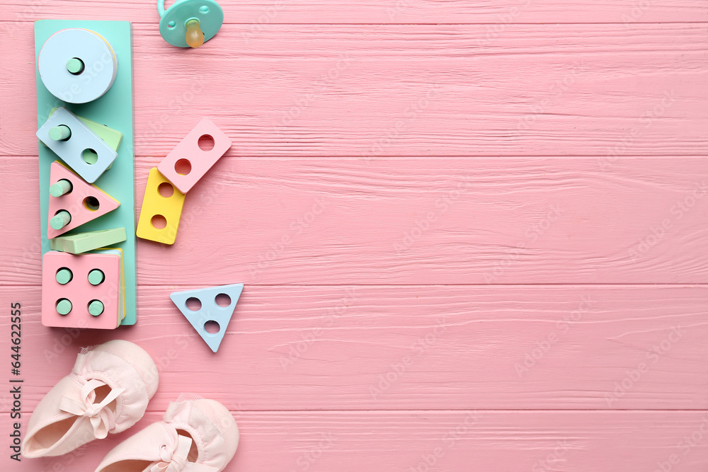 Composition with baby accessories and toys on pink wooden background