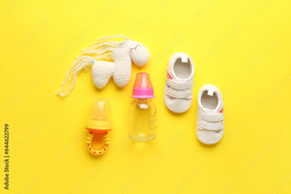 Set of baby accessories on yellow background