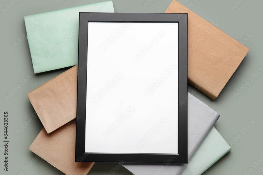 Blank picture frame with books on green background