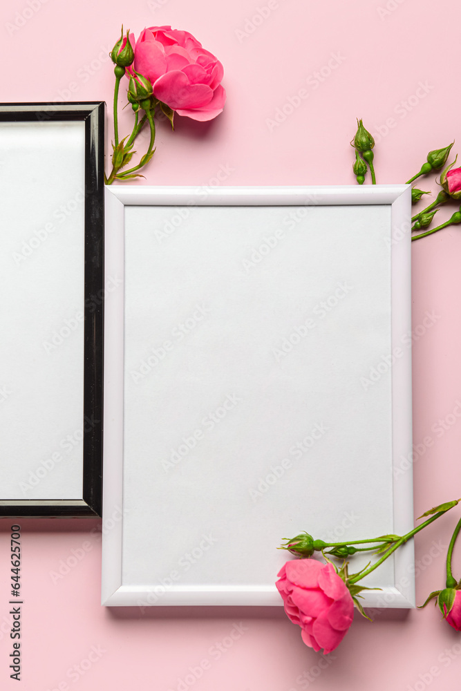 Blank photo frames with flowers on pink background