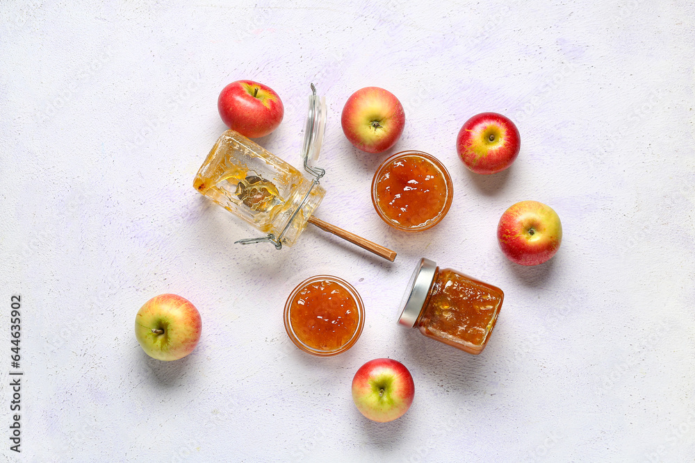 Glass bowls and jars of sweet apple jam on white background